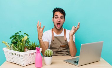 İspanyol yakışıklı adam son derece şaşırmış ve şok olmuş hissediyor. bahçe ve bitki konsepti