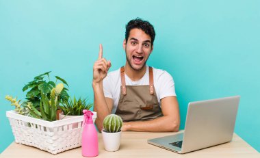 İspanyol yakışıklı bir adam bir fikri fark ettikten sonra mutlu ve heyecanlı bir dahi gibi hissediyor. bahçe ve bitki konsepti