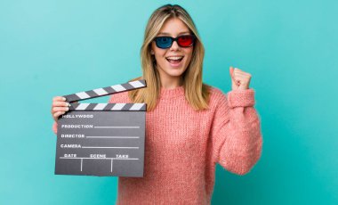 Güzel sarışın kadın şokta, gülüyor ve başarıyı kutluyor. Sinema kavramı