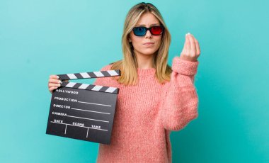 Güzel sarışın kadın kapiş ya da para hareketi yapıyor, sana ödemeni söylüyor. Sinema kavramı