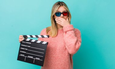 Güzel sarışın kadın, elleri ile ağzını kapatıyor ve şoka uğruyor. Sinema kavramı