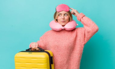 Güzel sarışın kadın şaşkın ve kafası karışık, kaşınıyor. uçuş yolcu kavramı