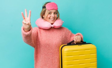 Güzel sarışın kadın gülümsüyor ve arkadaş canlısı görünüyor, üç numarayı gösteriyor. uçuş yolcu kavramı