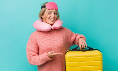 Güzel sarışın kadın neşeyle gülümsüyor, mutlu hissediyor ve bir konsept gösteriyor. uçuş yolcu kavramı