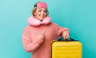 Güzel sarışın kadın neşeyle gülümsüyor, mutlu hissediyor ve bir tarafı işaret ediyor. uçuş yolcu kavramı