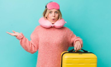 Güzel sarışın kadın şaşırmış ve şok olmuş görünüyor. Çenesi düşmüş ve elinde bir nesne var. uçuş yolcu kavramı