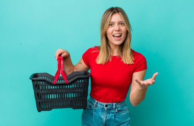 Güzel sarışın kadın sinirli, sinirli ve sinirli görünüyor. Alışveriş sepeti konsepti