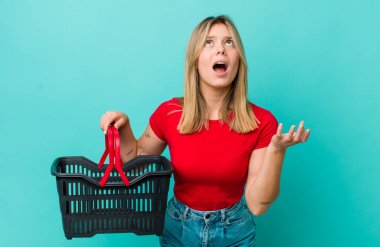 Güzel sarışın kadın umutsuz, hayal kırıklığına uğramış ve stresli görünüyor. Alışveriş sepeti konsepti