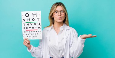 Güzel sarışın kadın şaşkın, şaşkın ve şüpheci hissediyor. optik görüş testi konsepti