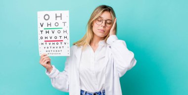 Güzel sarışın kadın bıkkın, bıkkın ve yorucu bir geceden sonra uykulu hissediyor. optik görüş testi konsepti