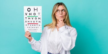 Güzel sarışın kadın düşünüyor, kuşkulu ve şaşkın hissediyor. optik görüş testi konsepti