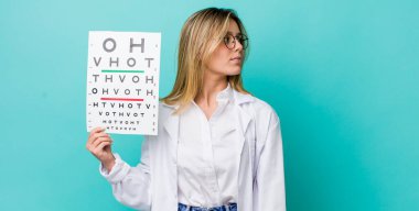 Profil görünümlü güzel sarışın kadın hayal mi kuruyor, hayal mi kuruyor yoksa hayal mi kuruyor? optik görüş testi konsepti