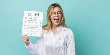 Güzel sarışın kadın agresif bir şekilde bağırıyor, çok kızgın görünüyor. optik görüş testi konsepti