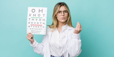 Güzel sarışın kadın kapiş ya da para hareketi yapıyor, sana ödemeni söylüyor. optik görüş testi konsepti