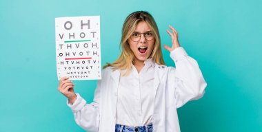 Güzel sarışın kadın ellerini havaya kaldırarak çığlık atıyor. optik görüş testi konsepti