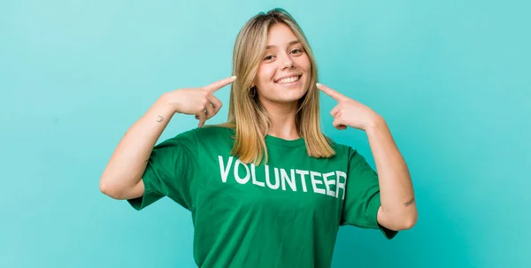 Bonita Mujer Rubia Sonriendo Con Confianza Apuntando Propia Sonrisa Amplia —  Fotos de Stock