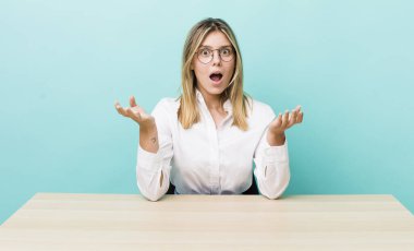 Güzel sarışın kadın inanılmaz bir sürprizle şaşkına döndü ve hayrete düştü. iş ve masa konsepti