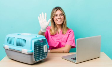 Güzel sarışın kadın gülümsüyor ve arkadaş canlısı görünüyor, beş numarayı gösteriyor. Veterinerlik kavramı