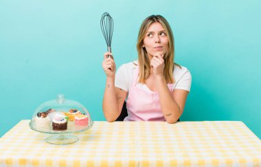 Güzel sarışın kadın düşünüyor, kuşkulu ve şaşkın hissediyor. Ev yapımı kek konsepti