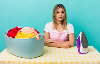 Güzel sarışın kadın üzgün, üzgün ya da kızgın ve yana bakıyor. Demir ve giysi konsepti