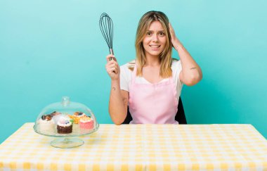 Güzel sarışın kadın stresli, endişeli ya da korkmuş, elleri başının üstünde. Ev yapımı kek konsepti