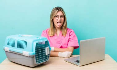 Güzel sarışın kadın iğreniyor, sinirleniyor ve dilini çıkarıyor. Veterinerlik kavramı