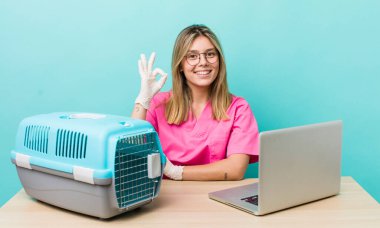 Güzel sarışın kadın kendini mutlu hissediyor, iyi bir jestle onaylıyor. Veterinerlik kavramı