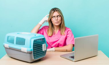 Güzel sarışın kadın şaşkın ve kafası karışık, kaşınıyor. Veterinerlik kavramı