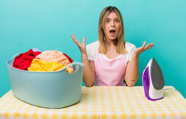 Güzel sarışın kadın şok olmuş ve şaşırmış hissediyor. Demir ve giysi konsepti