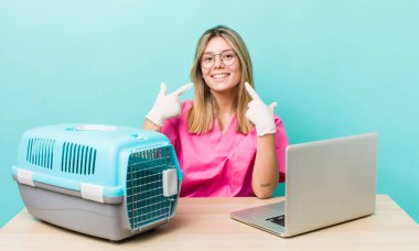 Güzel sarışın kadın kendi gülüşünü göstererek kendine güvenerek gülümsüyor. Veterinerlik kavramı