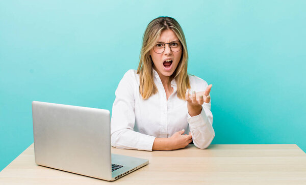 красивая блондинка выглядит злой, раздраженной и расстроенной. бизнес и концепция рабочего стола