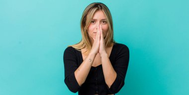 Genç, güzel, sarışın bir kadın endişeli, umutlu ve dindar, avuçlarına bastırılmış, af dileyen, sadakatle dua eden.