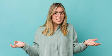 Genç, güzel, sarışın bir kadın bilgisiz ve kafası karışık, hangi seçeneği seçeceğinden emin değil, merak ediyor.