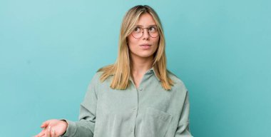 Genç, güzel, sarışın, şapşal ve komik görünümlü, şaşı bakışlı, şakacı ve şakacı bir kadın.