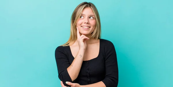 Jovem Mulher Loira Bonita Sorrindo Feliz Sonhando Acordado Duvidando Olhando — Fotografia de Stock