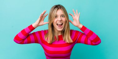 Genç, güzel sarışın kadın panik ve öfke içinde bağırıyor. Şok olmuş, korkmuş ya da öfkeli. Elleri başının yanında.