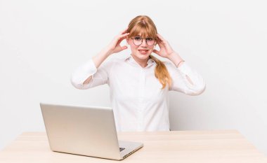 Kızıl saçlı güzel kadın stresli, endişeli ya da korkmuş, elleri başının üstünde. iş kavramı