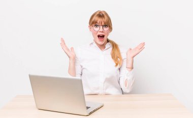 Kızıl saçlı güzel kadın kendini mutlu hissediyor ve inanılmaz bir şeye hayret ediyor. iş kavramı