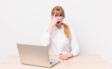 Kızıl saçlı güzel bir kadın şok olmuş, korkmuş ya da korkmuş görünüyor. iş kavramı