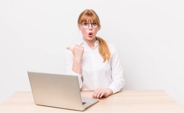 Kızıl saçlı, güzel bir kadın inançsızlıktan şaşkın şaşkın bakıyor. iş kavramı