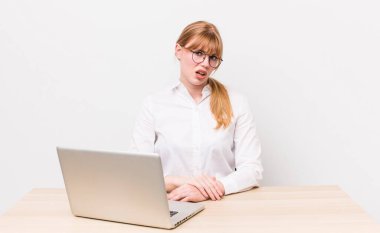 Kızıl saçlı güzel kadın şaşkın ve şaşkın hissediyor. iş kavramı