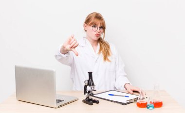 Kızıl saçlı, güzel bir kadın kendini kötü hissediyor, baş parmağını kaldırıyor. Mikroskobik bilim adamı.