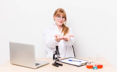 Kızıl saçlı, güzel bir kadın arkadaşça gülümsüyor ve bir konsept sunuyor. Mikroskobik bilim adamı.