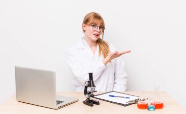 kızıl saçlı güzel bir kadın neşeli bir şekilde gülümsüyor, mutlu hissediyor ve bir konsept gösteriyor. Mikroskobik bilim adamı.