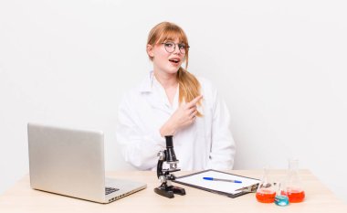 Kızıl saçlı, güzel bir kadın heyecanlı ve şaşırmış görünüyor. Mikroskobik bilim adamı.