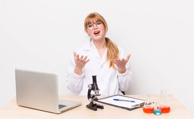 Kızıl saçlı güzel kadın umutsuz, hayal kırıklığına uğramış ve stresli görünüyor. Mikroskobik bilim adamı.