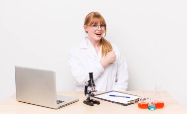 Kızıl saçlı güzel bir kadın kendini mutlu hissediyor ve bir meydan okumayla yüzleşiyor ya da kutluyor. Mikroskobik bilim adamı.