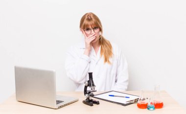 Kızıl saçlı, güzel bir kadın bıkkın, yorgun ve uykulu hissediyor. Mikroskobik bilim adamı.