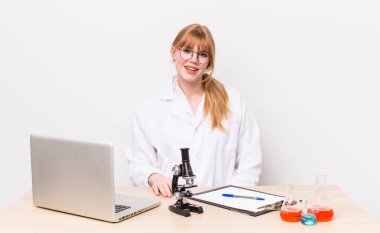 Kızıl saçlı güzel kadın mutlu ve hoş bir şekilde şaşırmış görünüyor. Mikroskobik bilim adamı.