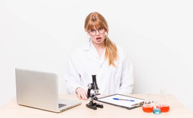 Kızıl saçlı güzel kadın şaşkın ve şaşkın hissediyor. Mikroskobik bilim adamı.